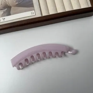 Gedetailleerd overzicht van een macaronroze bananenklem met tanden voor stevige grip