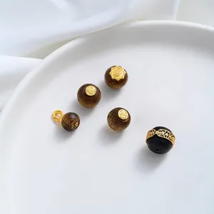 Detail van 24K vergulde agarwood kralen met traditionele symbolen voor DIY sieraden