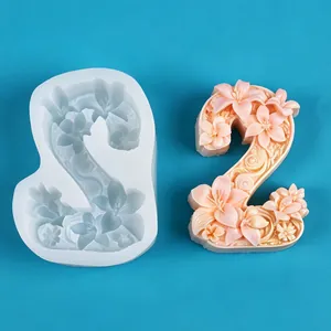 Close-up view of number 2 floral relief silicone mold and peach-colored finished candle