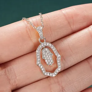 Detailed macro view of silver Hamsa Hand pendant necklace encrusted with brilliant stones.