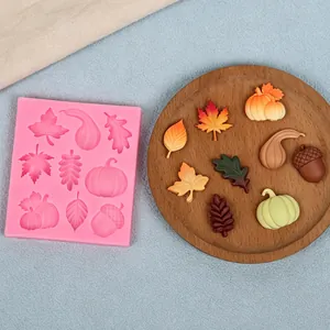 Detail view of pink silicone autumn leaf and pumpkin mold with finished fondant shapes