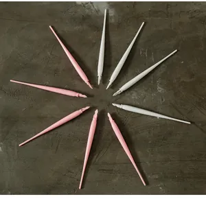 Radial layout of pink and white plastic scratch art pens for kids on a textured gray surface