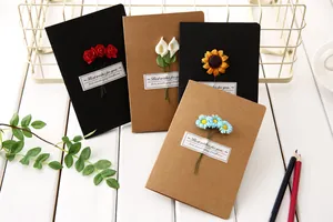 Detail view of vintage kraft paper greeting cards with colorful dried flowers decorations