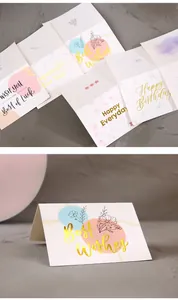 Close-up of elegant gold foil greeting cards with floral patterns and heartfelt wishes.