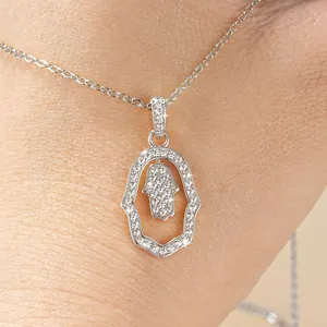 Close-up of silver Hamsa hand pendant necklace with sparkling cubic zirconia inlay