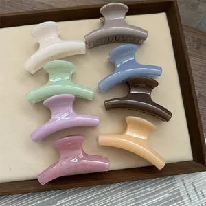 Detail view of small jelly-textured shark hair claw clips in assorted pastel colors.