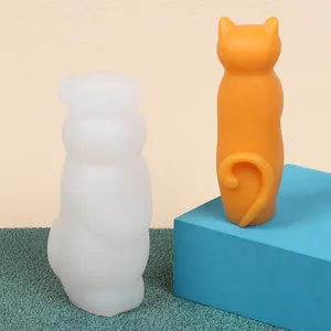 Detail view of 3D cat shaped silicone mold alongside a finished orange candle ornament