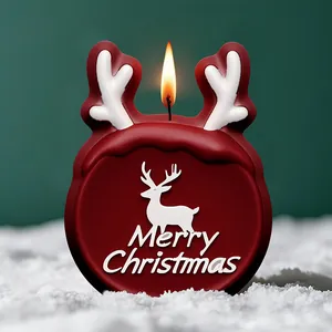 Bougie de Noël festive en forme de renne rouge avec texte Joyeux Noël sur de la neige