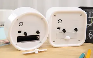 Detail back view of minimalist white battery operated alarm clocks showing controls.