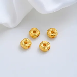 Macro-opname van vier 24K vergulde tussenkralen voor het maken van DIY-sieraden.
