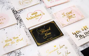Close-up van goudgestempelde wenskaarten met elegante marmertexturen en tekst.
