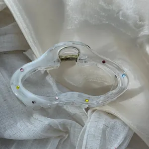 Detailed view of a clear irregular cloud-shaped hair claw clip with colorful rhinestones