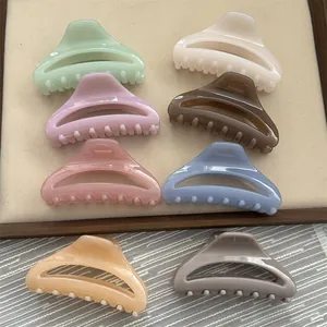Close-up detail view of minimalist colorful hair claw clips in various elegant pastel shades