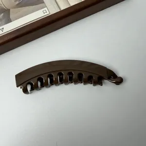Detailoverzicht van een donkerbruine bananenhaarklem met tanden voor paardenstaartstyling.