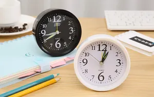 Detailed view of minimalist round black and white alarm clocks on a wooden desk