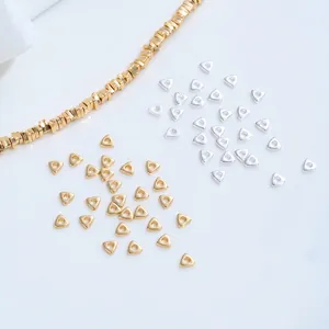 Close-up macro detail of triangle gold and silver plated spacer beads for DIY jewelry
