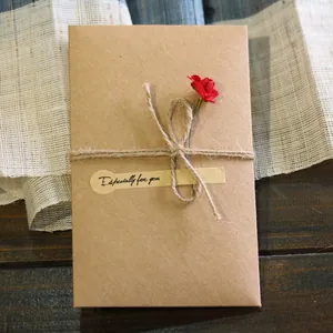 Vintage kraft paper greeting card with handmade red dried flower and twine decoration