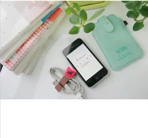 Detailweergave van een roze konijnenleren kabelorganizer met witte USB-kabel