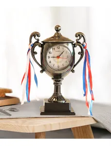 Close-up of a creative metallic trophy-shaped alarm clock with colorful ribbons