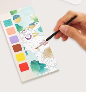 Close-up of a hand painting a portable watercolor coloring book with built-in pigments