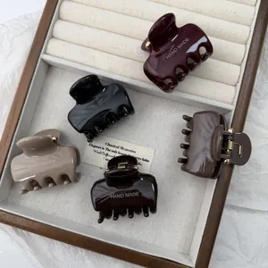 Set glanzende mini haarklemmen in diverse aardetinten met gouden details.