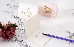 Detail van elegante wenskaarten met goudfolie en marmerpatroon gepresenteerd op bureau
