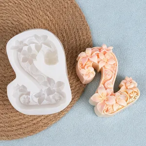 Macro detail of number 2 floral relief silicone mold and finished peach flower wax candle