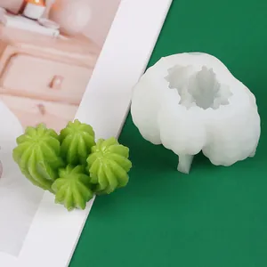 Vue détaillée d'un moule en silicone cactus 3D à côté d'une bougie succulente verte.