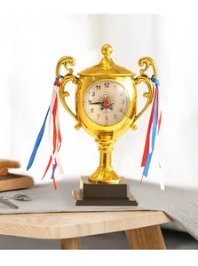 Close-up of a creative gold trophy-shaped alarm clock with colorful ribbons