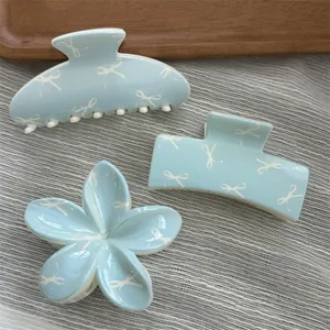 Set of light blue hair claw clips featuring sweet white bow patterns in three shapes