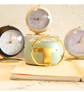 Detailed view of a modern mint green mini alarm clock with an elegant gold stand