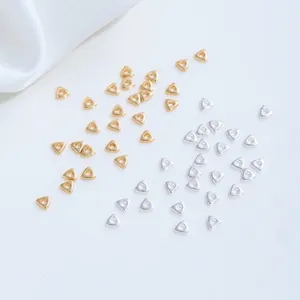 Macro view of small triangle spacer beads in gold and silver finishes for DIY jewelry making