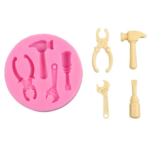 Vue détaillée du moule en silicone rose avec décorations de fondant en forme d'outils