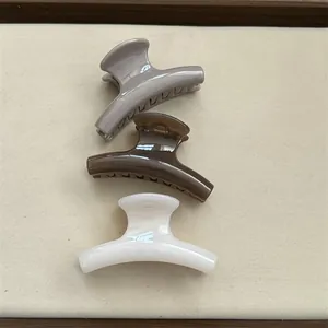 Set of three glossy jelly-colored small hair claw clips in mauve, brown, and white