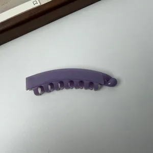 Detailopname van een paarse matte plastic banaan haarklem voor paardenstaarten