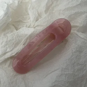 Nahaufnahme einer rosa Jelly PC gebogenen Haarklammer auf weißem Papierhintergrund