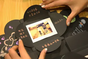 Detalle de álbum de fotos DIY caja de explosión con mecanismo creativo y notas decorativas