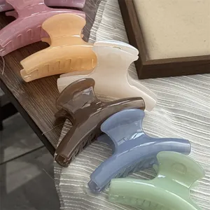 Close-up of small curved jelly hair claw clips in various translucent pastel colors