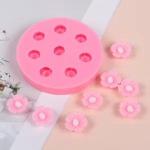 Close-up of pink cherry blossom silicone mold with finished flower pieces for DIY craft.