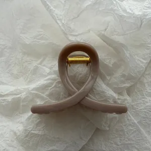 Close-up of jelly-textured hair claw clip in taupe with elegant butterfly loop design.