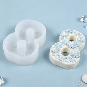Silicone number 8 mold with floral relief and finished candle on blue background