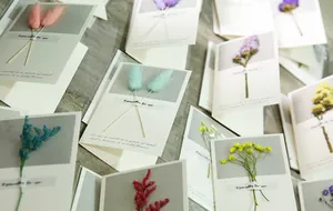 Close-up detail of various handmade greeting cards featuring colorful real dried flowers