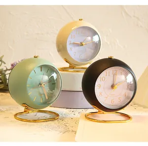 Macro view of three minimalist spherical quartz desk clocks in green beige and black color.