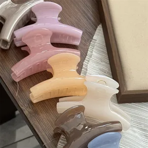 Close-up view of glossy jelly-colored small shark hair clips in assorted pastel shades.