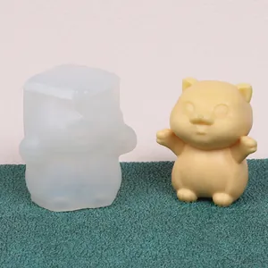 Close-up of a cat silicone mold alongside its finished yellow wax figurine ornament