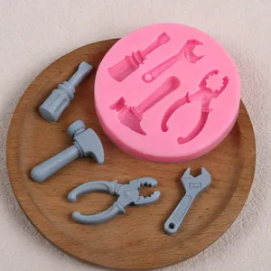 Détail du moule circulaire en silicone rose avec diverses formes d'outils de bricolage.