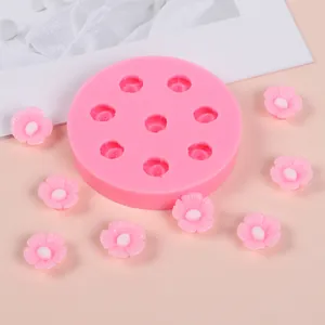 Detail view of cherry blossom silicone mold with finished small pink resin flowers on a table.