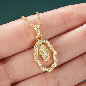 Close-up of a 14k gold-filled Hamsa hand pendant necklace with sparkling stones.