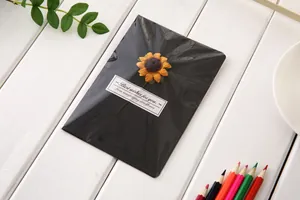 Top-down view of black creative greeting card featuring a dried sunflower ornament