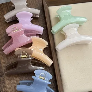 Detailed view of colorful pastel mini shark hair clips on a wooden tray